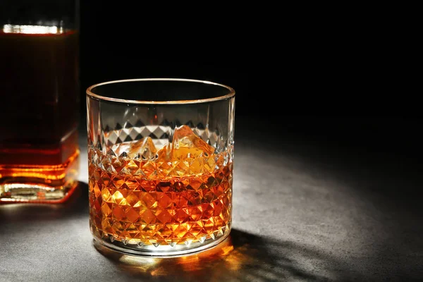 Glass of whisky on grey textured table — Stock Photo, Image