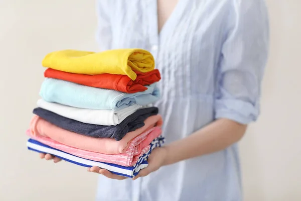 Mulher segurando pilha de roupas — Fotografia de Stock