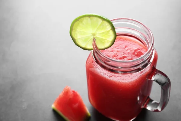 Jug with smoothie and watermelon slice — Stock Photo, Image