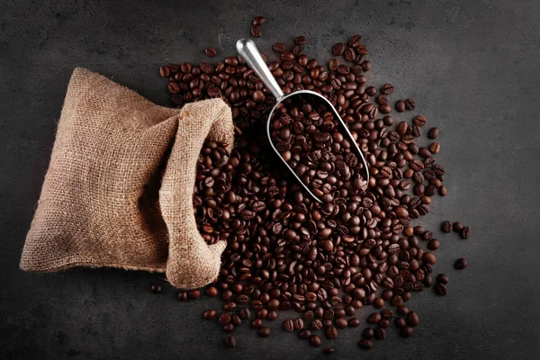 Bolsa e colher de metal com grãos de café — Fotografia de Stock