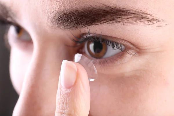 Женщина ставит контактные линзы в глаза — стоковое фото