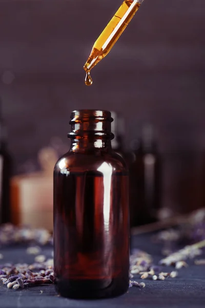 Lavendelöl fällt in Flasche — Stockfoto