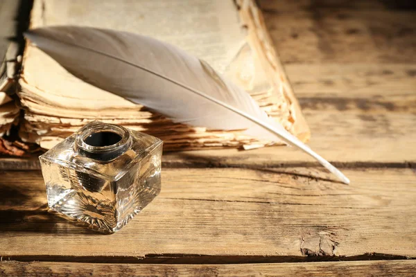 Fjäder penna med bläckhorn och stack av papper — Stockfoto