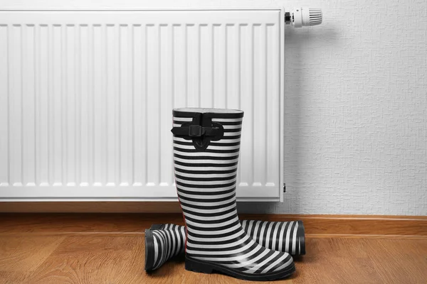 Riscaldamento radiatore con stivali di gomma — Foto Stock