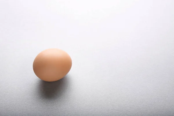 Rått ägg på grå — Stockfoto