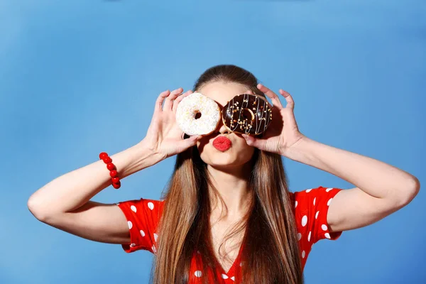 Lezzetli donuts renk arka plan üzerinde olan komik kadın — Stok fotoğraf