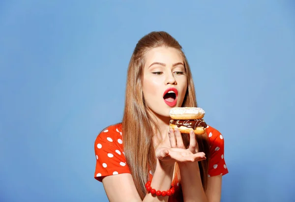 Woman eating tasty donuts — Stok fotoğraf