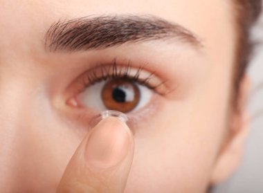 Kontakt lens gözlerinin içine koyarak kadın