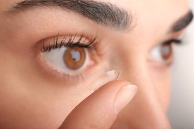 Kontakt lens gözlerinin içine koyarak kadın
