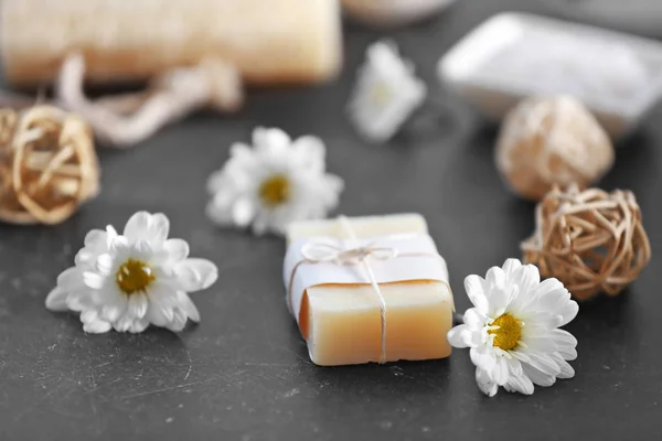 Soap and daisy flowers on grey table — Stock Photo, Image