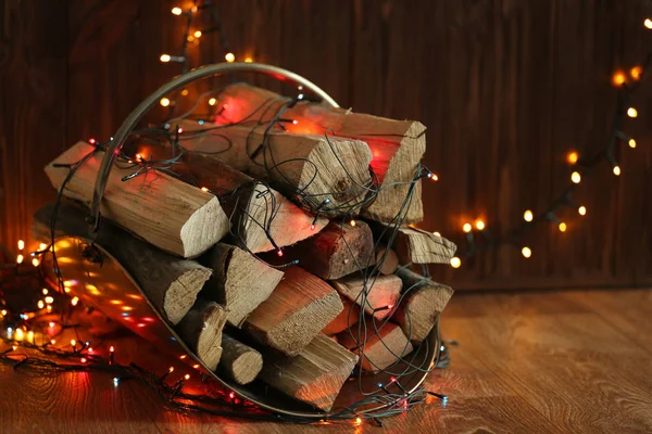 Stack of firewood and garland — Stock Photo, Image