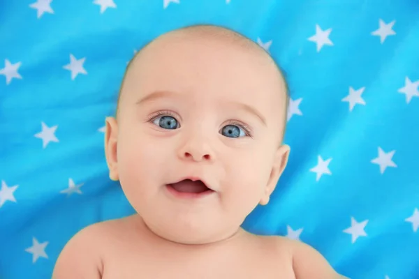 Söt baby som ligger på färg överkast, på nära håll se — Stockfoto