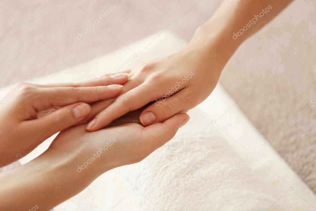 Specialist massaging female hand
