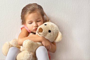 Sad little girl with teddy bear   clipart