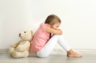 Oyuncak ayı katta oturan üzgün küçük kız  