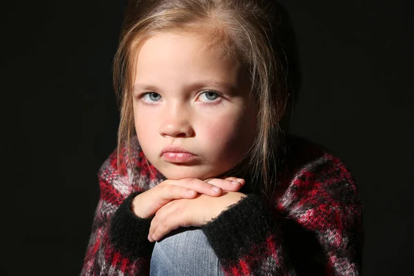 Разочарованная маленькая девочка на черном фоне — стоковое фото