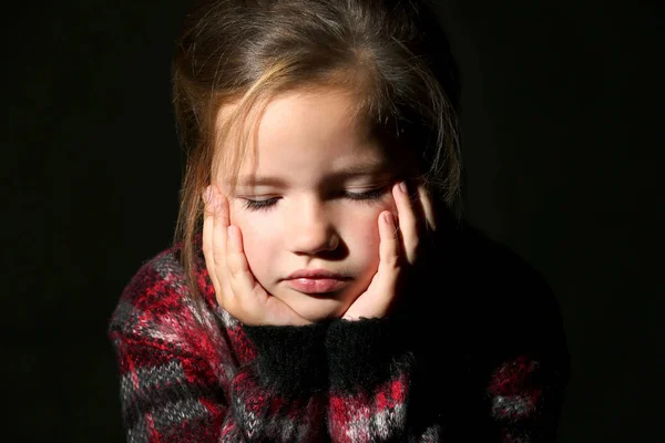 Грустная маленькая девочка на черном фоне — стоковое фото