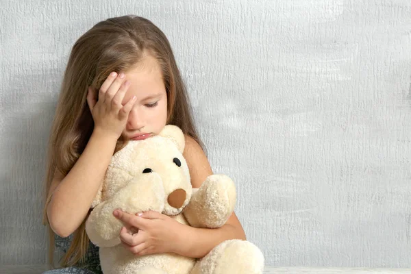 Сумна дівчинка з плюшевим ведмедем — стокове фото