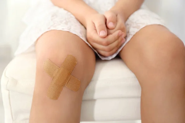 Knie eines kleinen Mädchens mit klebrigem Gips — Stockfoto