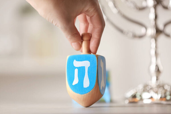 Female hand spinning wooden dreidel 