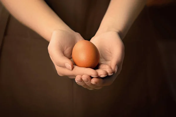 Женщина держит в руках сырое яйцо — стоковое фото