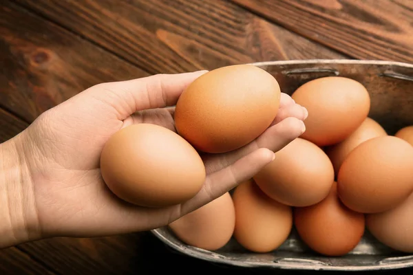 Vrouwelijke hand bedrijf rauwe eieren — Stockfoto