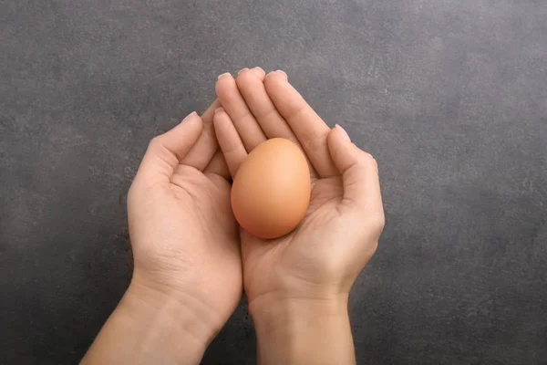 Woman hands holding raw egg — Stock Photo, Image