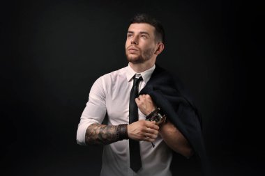 Koyu arka plan üzerinde poz genç dövmeli adam
