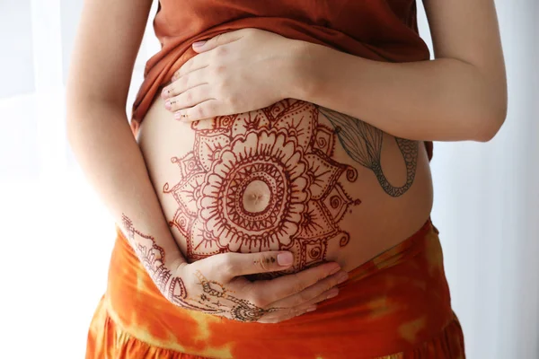 Pregnant woman with henna tattoo on belly — Stock Photo, Image