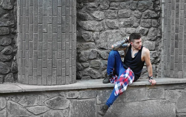 Jovem Tatuado Homem Posando Pedra Parede Fundo — Fotografia de Stock