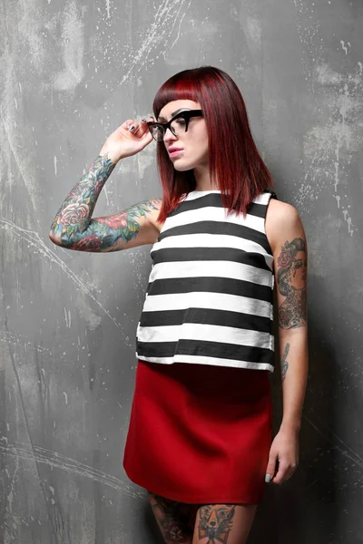 Красивая девушка с татуировкой на цветном фоне — стоковое фото