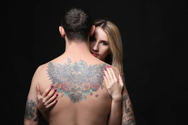 Vrouw knuffelen tattooed man — Stockfoto