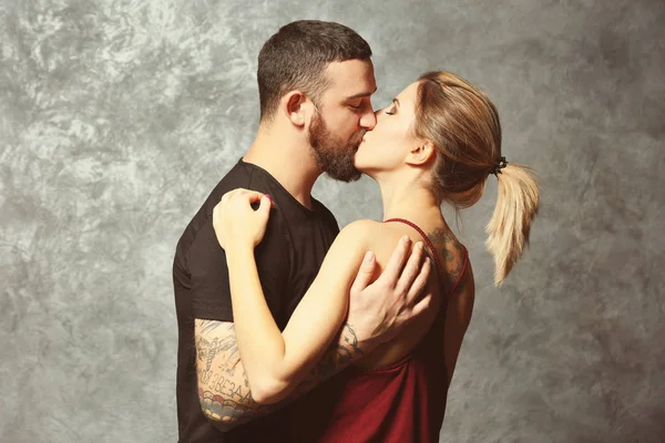 Portrait of kissing tattooed couple