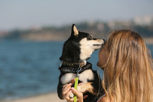 Woman with cute little Shiba Inu dog at riverside