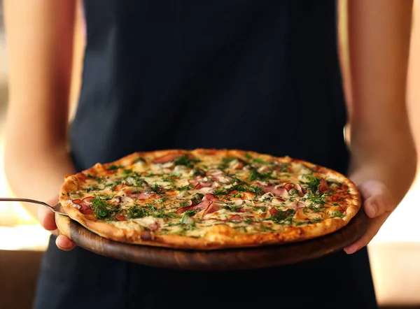 Frau hält Teller mit Pizza — Stockfoto