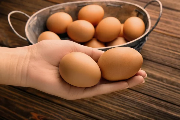 Weibliche Hand mit rohen Eiern — Stockfoto