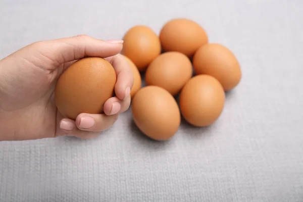 Kvinnlig hand innehav rått ägg — Stockfoto