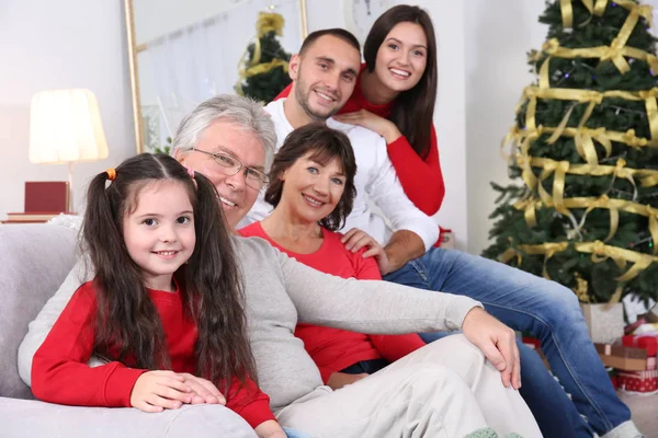 Ευτυχισμένη Οικογένεια Κάθεται Στον Καναπέ Στο Σαλόνι Διακοσμημένο Για Χριστούγεννα — Φωτογραφία Αρχείου