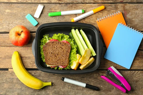 Lunchbox met voedsel en briefpapier — Stockfoto