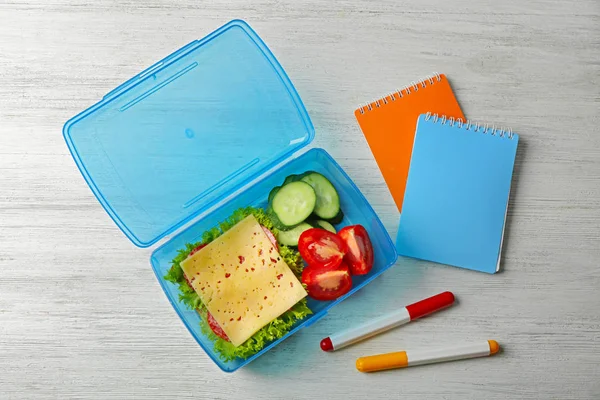 Lunchbox met voedsel en briefpapier — Stockfoto