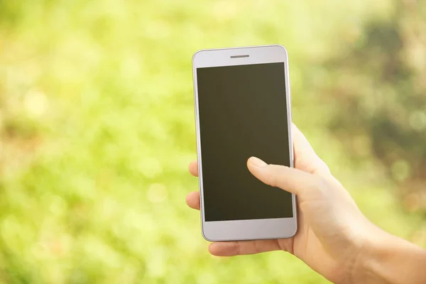 Kvinna anläggning modern mobiltelefon — Stockfoto