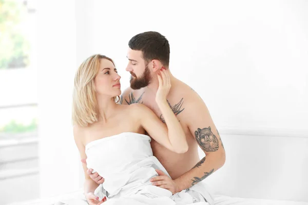 Dövmeli çift yatak sarılma — Stok fotoğraf