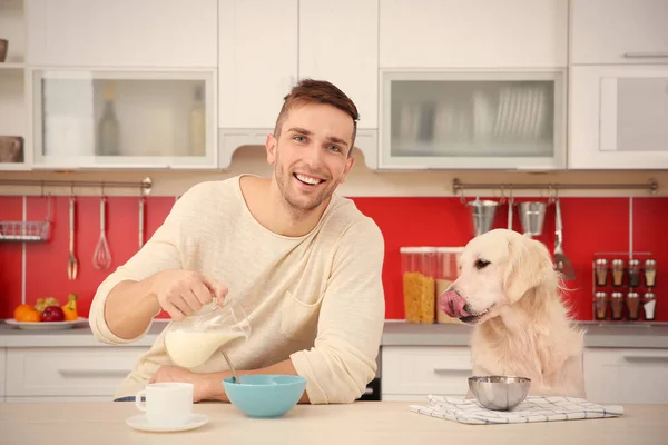 Människa och hund njuter av frukost — Stockfoto