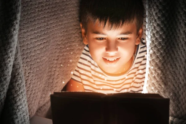 Cute Boy Reading Book Blanket Night Magic Light Coming Out — Stock Photo, Image