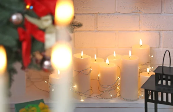 Candles with garland in fireplace — Stock Photo, Image