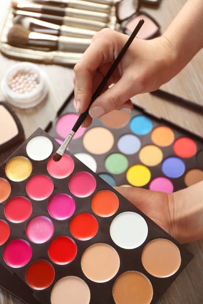 Female hands with palette of lipsticks — Stock Photo, Image