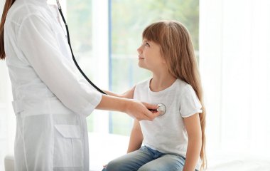 Küçük kız inceleyerek çocuk doktoru