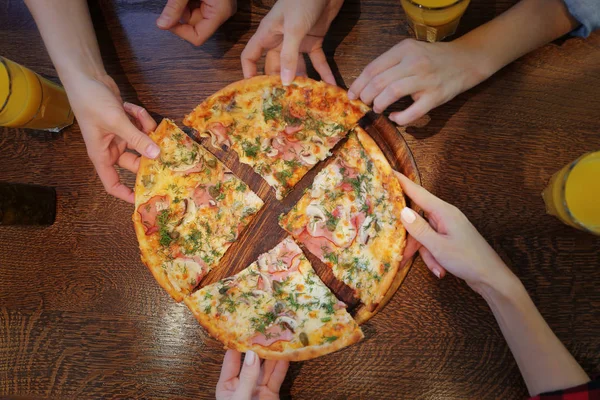 Amigos tomando fatias de pizza saborosa — Fotografia de Stock