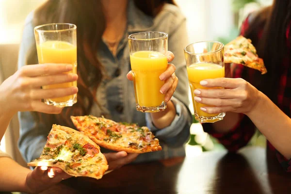 women with juice and pizza