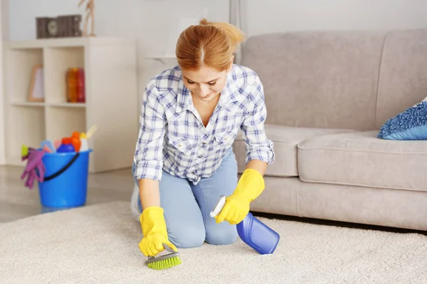 Frau putzt Teppich zu Hause — Stockfoto